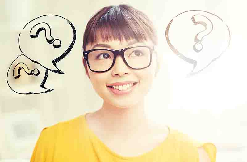 happy asian woman in glasses over question marks intelligence and undue influence
